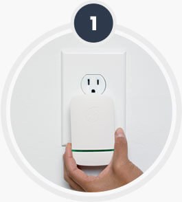 A hand pressing the plug-in unit into a wall outlet
